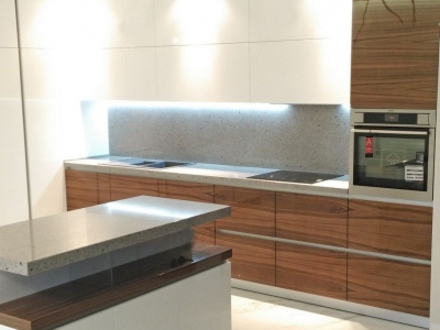 Каменная столешница со стеновой панелью гармонично сочетается с фактурами фасадов кухни